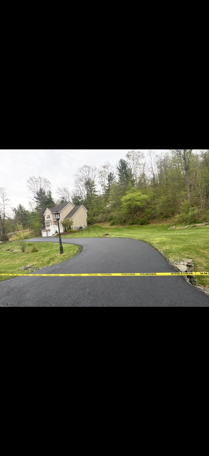 Same driveway with a fresh dark sealcoat after the work