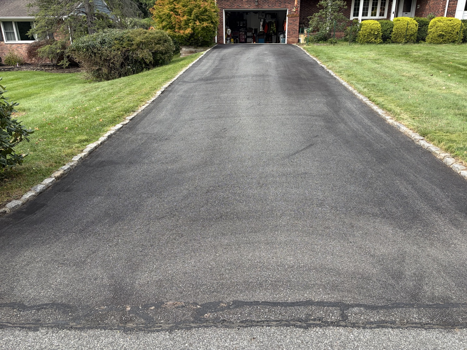 Residential driveway with faded asphalt before sealcoating